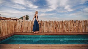 A pool with a wooden deck and a wooden fence in the background. - Nobu Riad (Marrakech)