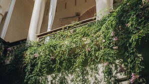 A building with a covered patio area, columns, and a hanging light fixture. - Nobu Riad (Marrakech)