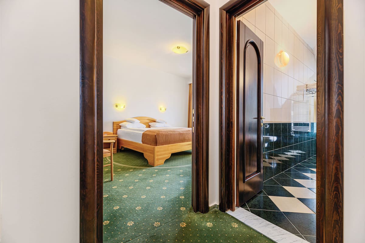 Ein Hotelzimmer mit Bett, Nachttisch und Spiegel.