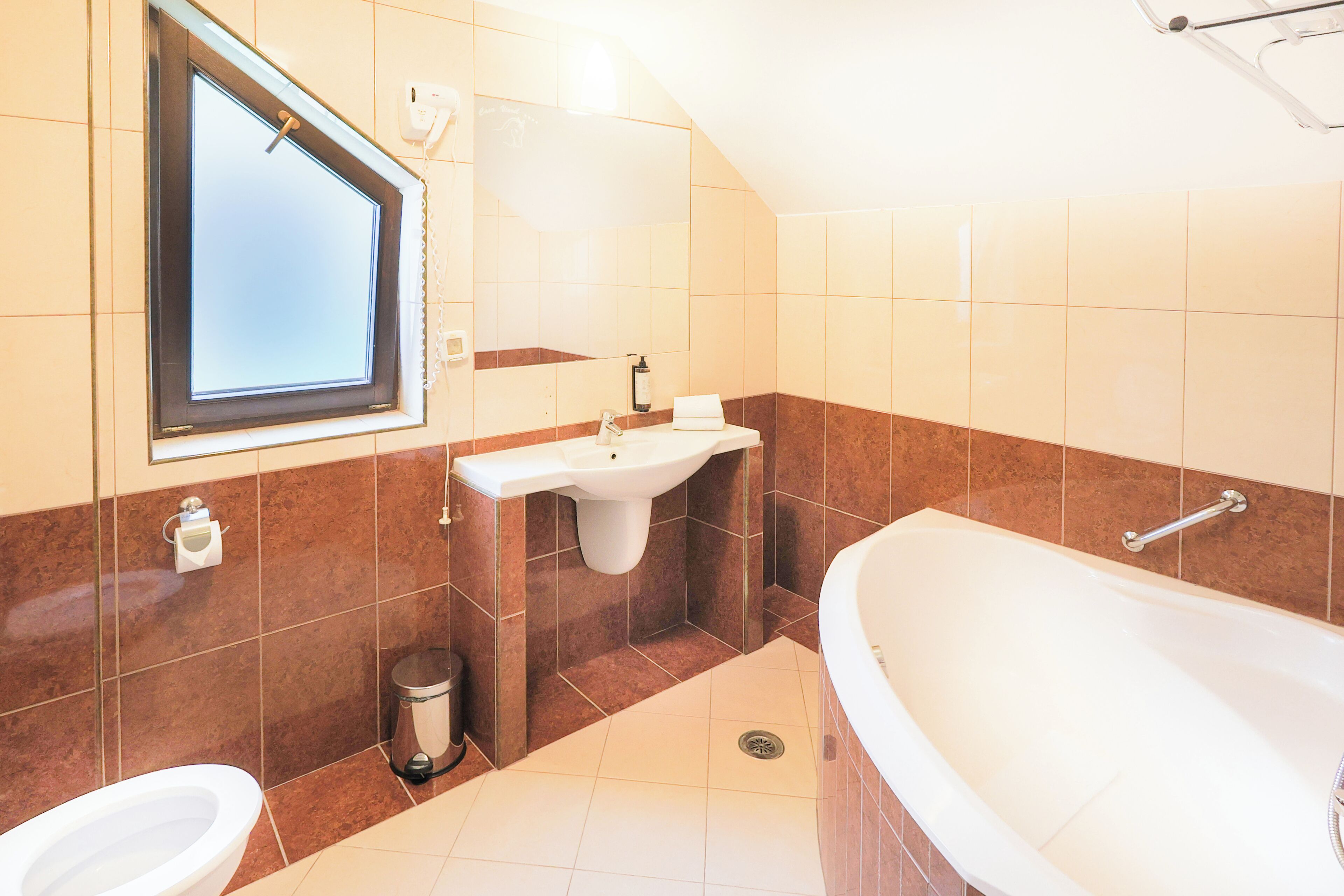 A bathroom with a toilet, sink, and bathtub.