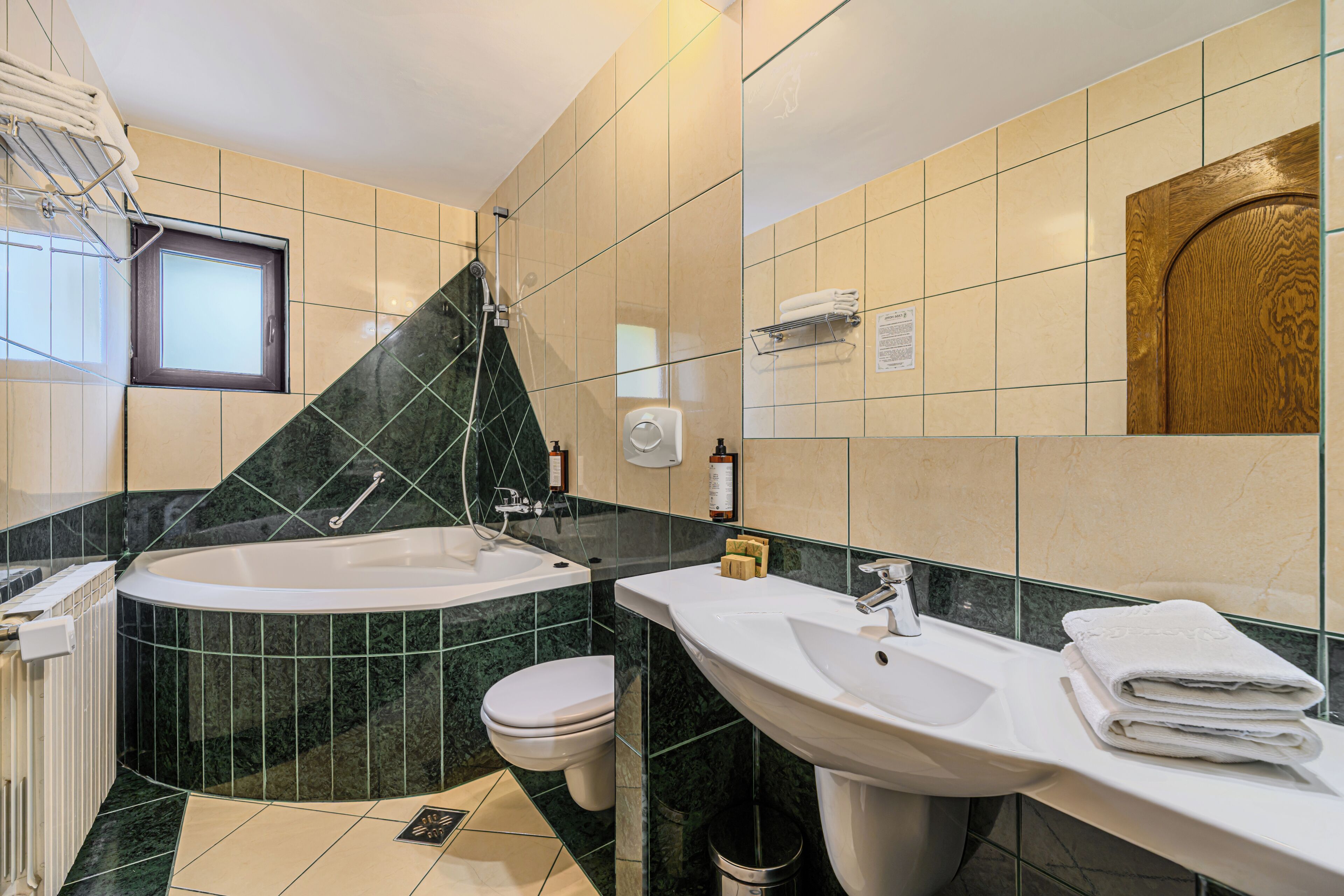 Et badeværelse med badekar, toilet og håndvask.