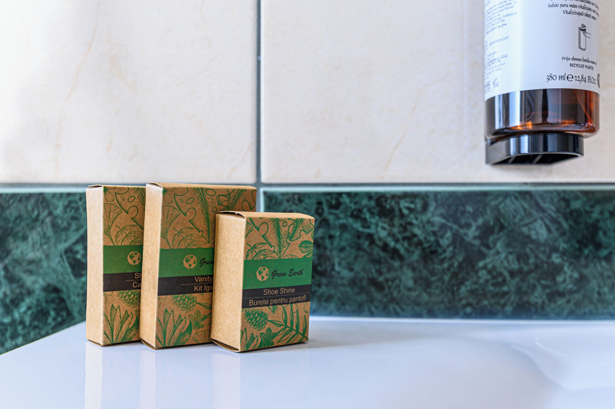 Three shoe shine kits on a white surface with a green and white tiled backsplash.