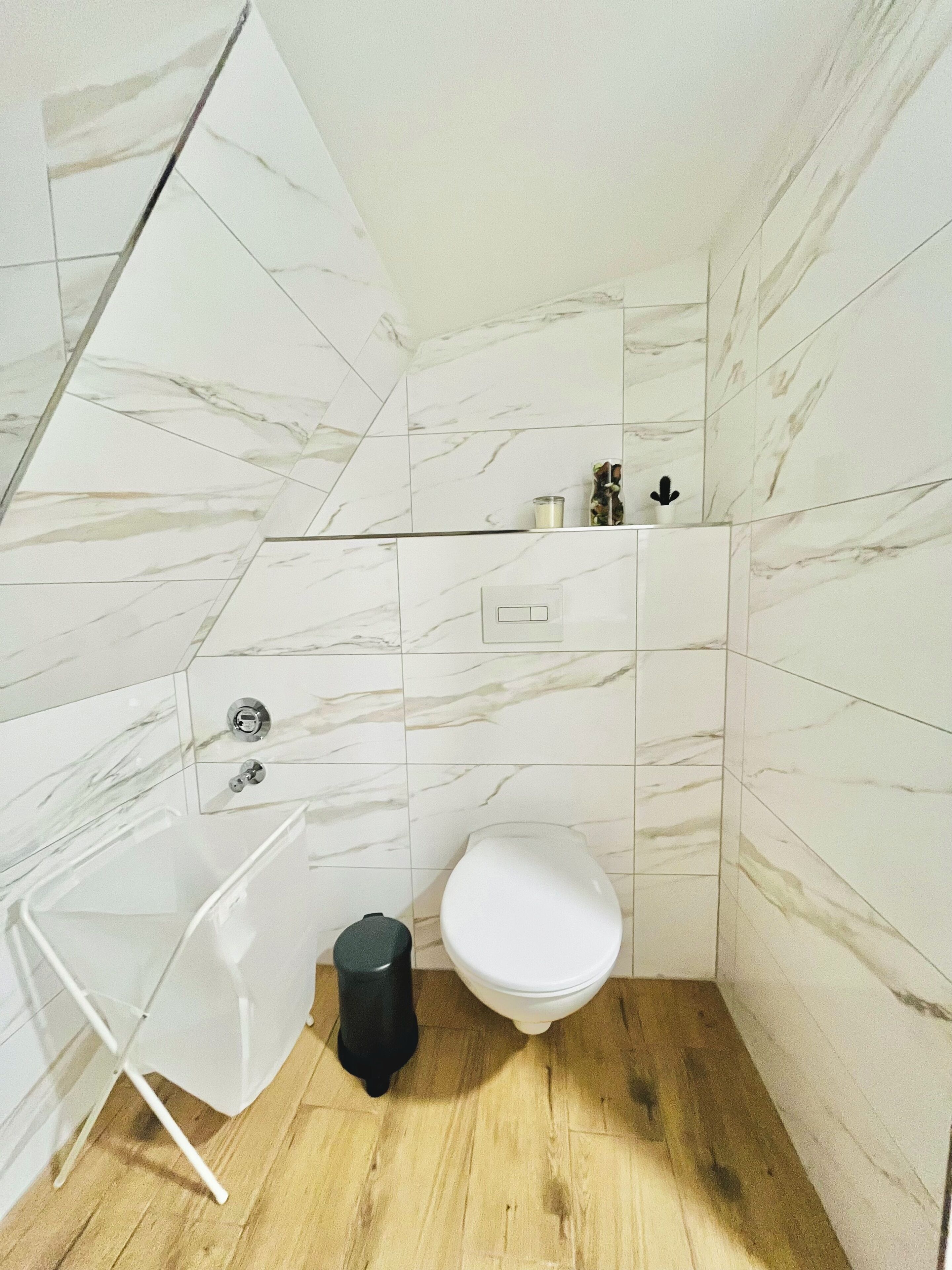 Un baño con inodoro blanco, lavamanos y espejo.