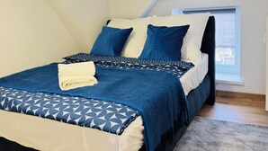 A bedroom with a bed, pillows, and a window. - Modern vacation apartment in Anklam - right next to the city center (Anklam)