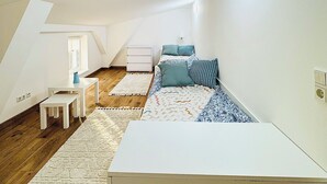 A bedroom with a bed, a nightstand, a small table, and a window. - Modern vacation apartment in Anklam - right next to the city center (Anklam)