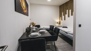 A modern, compact hotel room with a dining area, a bed, and a small sitting area. - Cosy apartment for 4 people with WIFI and TV (Jindrichuv Hradec)