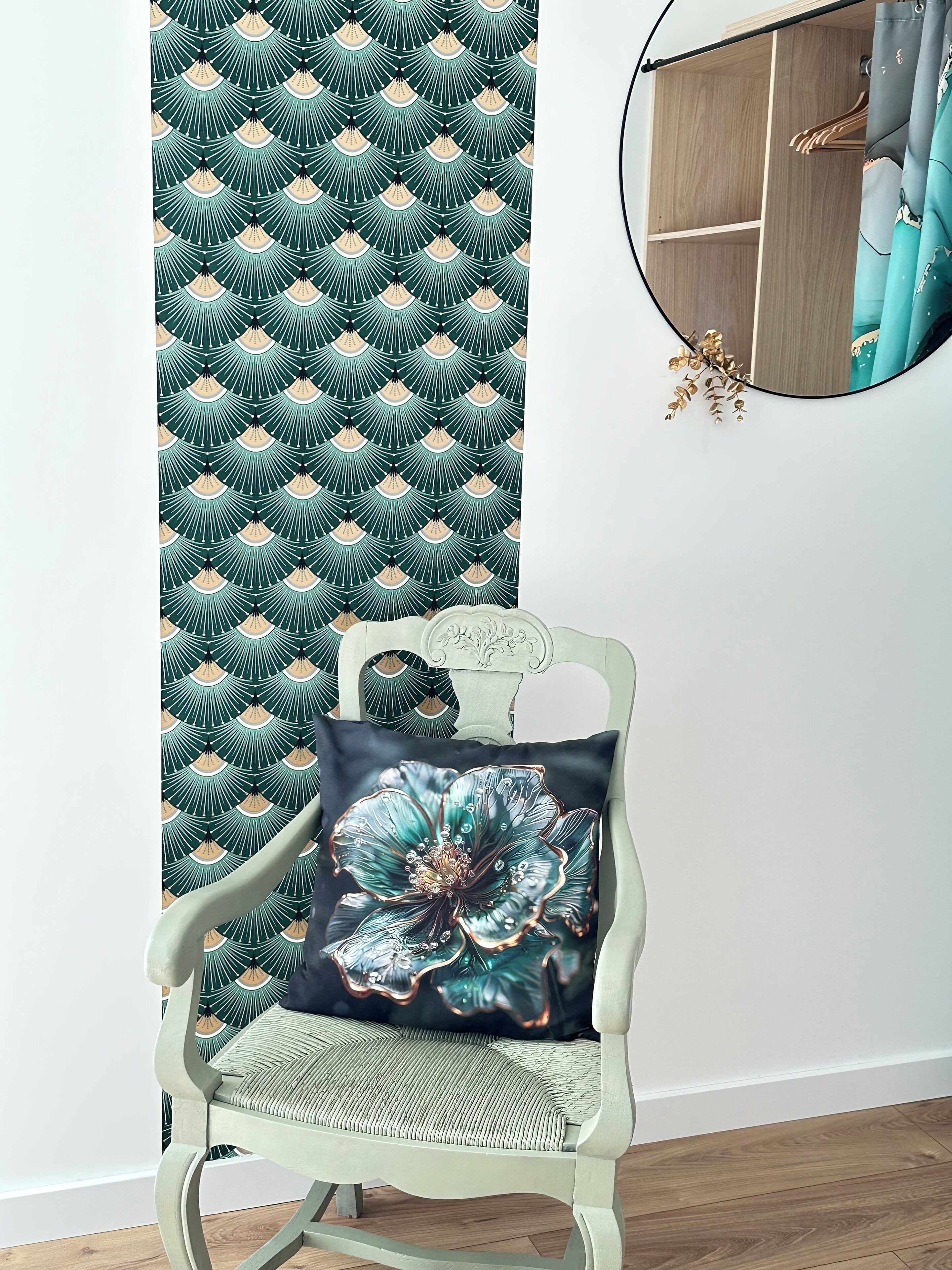 A chair with a cushion featuring a large flower design, positioned in front of a wall with a green and beige pattern.