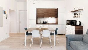 Una cucina moderna con un armadietto in legno, un tavolo da pranzo con sedie e un forno a microonde integrato.