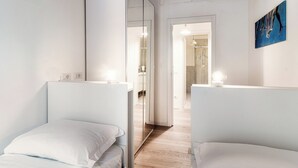 A modern hotel room with a large mirror, a bed, and a bathroom visible through an open door. - Pleasant Family Apt next to Lake Como (Como)