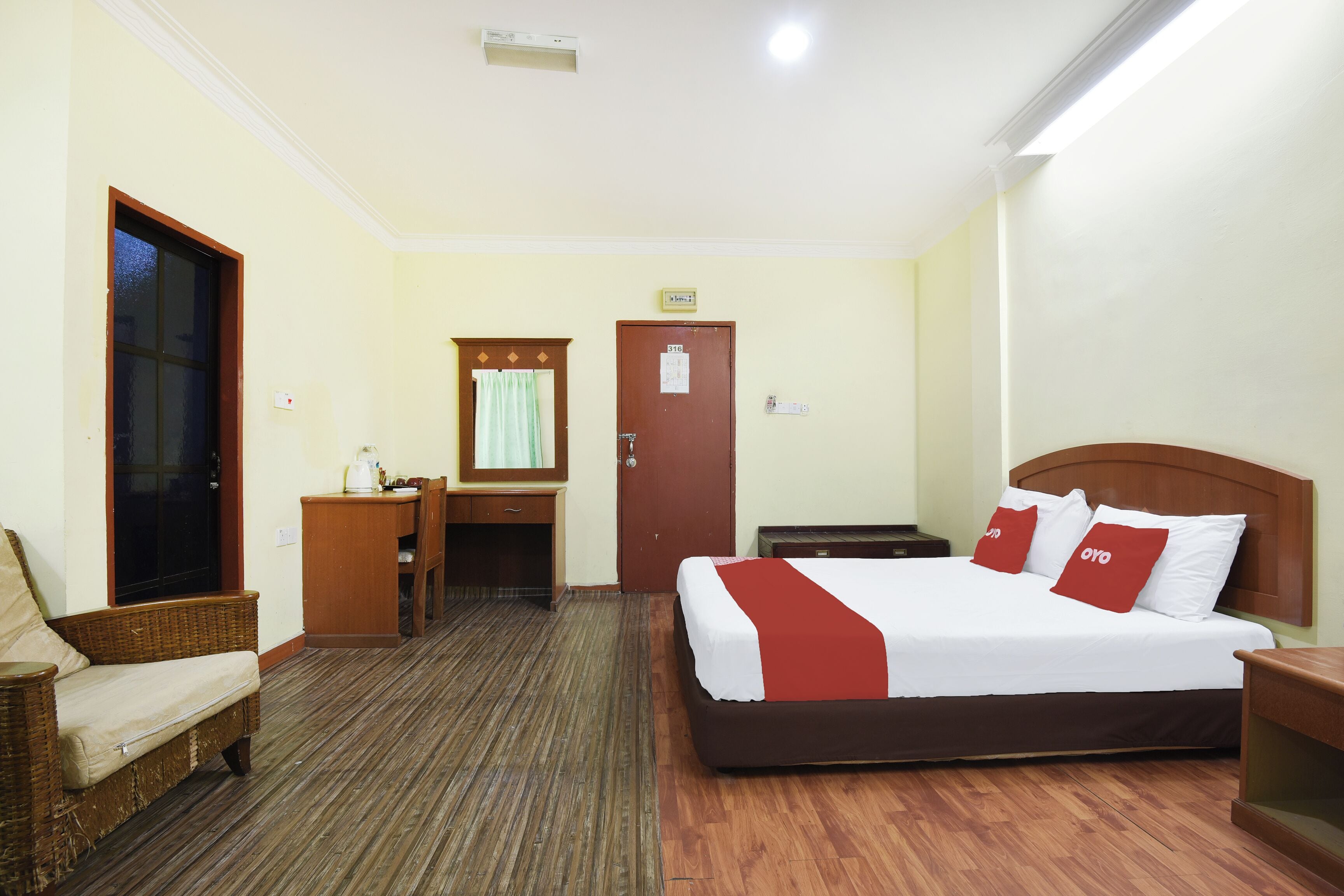 Una habitación de hotel con cama, escritorio, silla y armario.