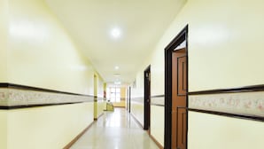 A long, narrow hallway with cream-colored walls and a tiled floor.