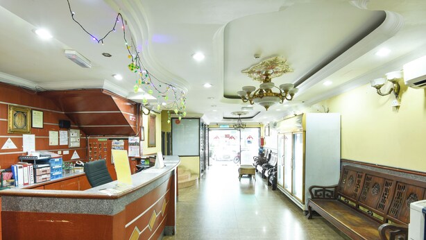 A reception area with a counter, chairs, and a bench.