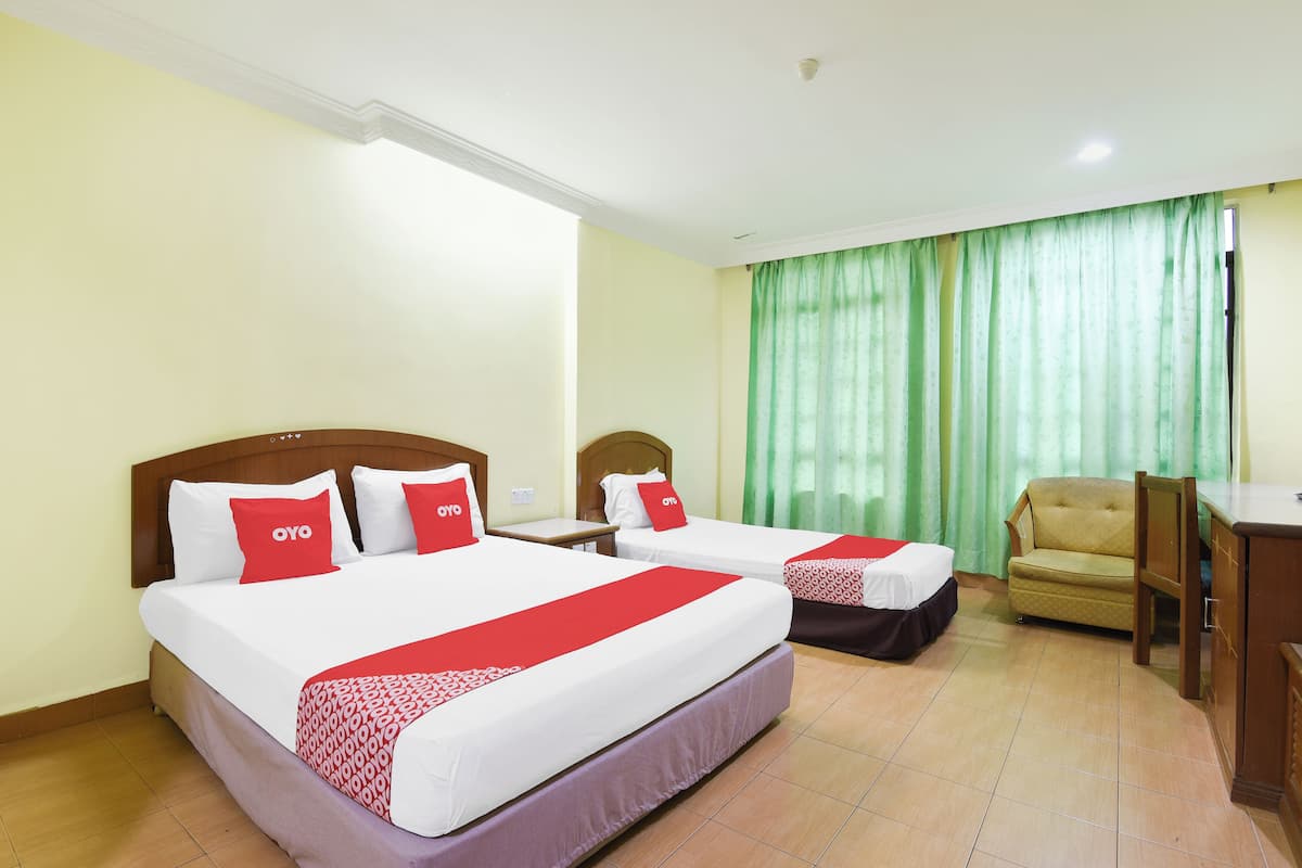 A hotel room with two beds, a sofa, a desk, and a chair.