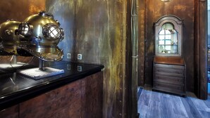 A room with a vintage-style stove, wooden cabinets, and a large mirror with a decorative frame. - The Kraken Inn (Bergamo)