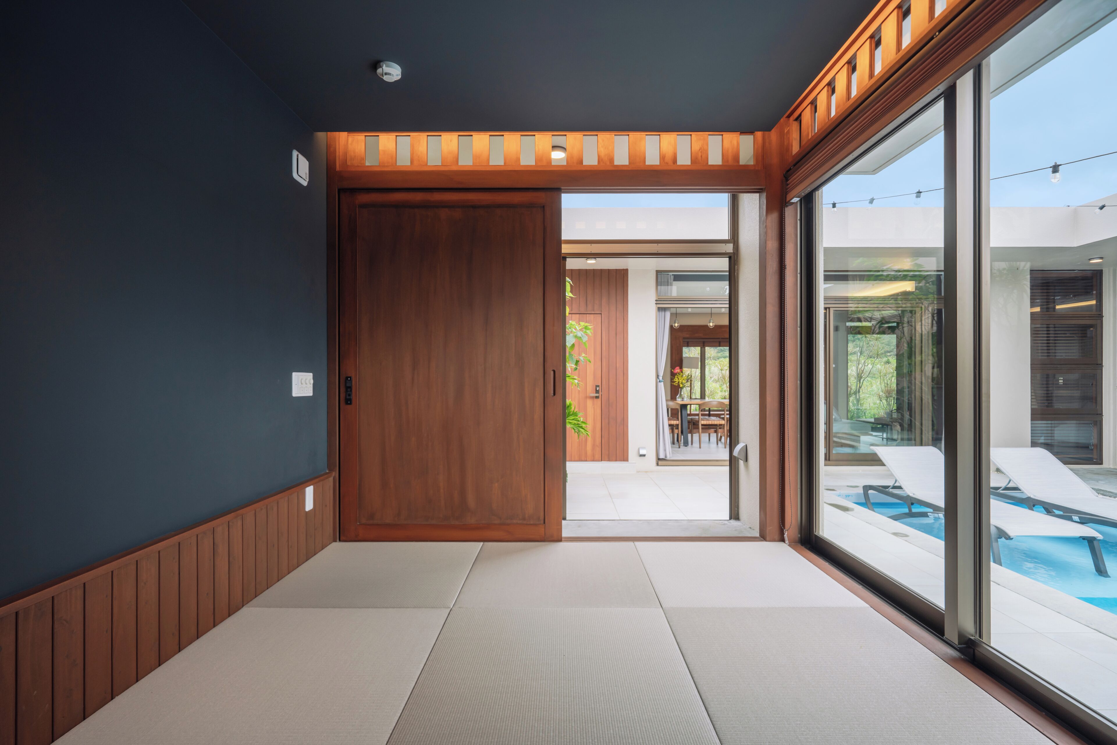 Un interior moderno con un  puerta corrediza que da a una zona de piscina.
