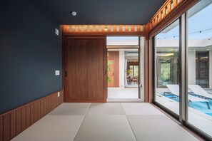 A modern interior with a sliding door leading to a pool area. - Reflexion Villas GLANZ (Nago)
