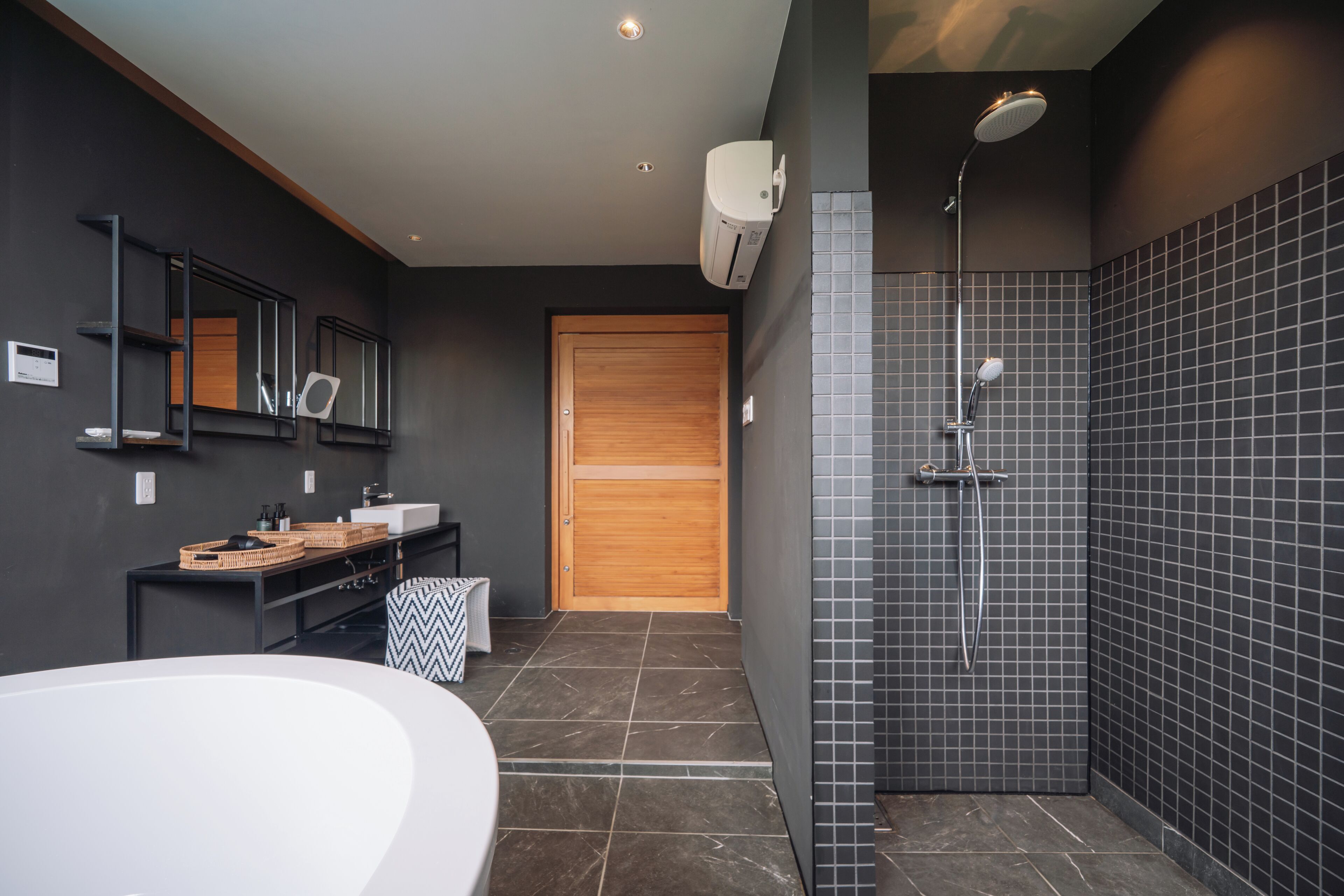 Un baño moderno con una bañera independiente, un tocador con espejo y una zona de ducha con cabezal de ducha de lluvia.