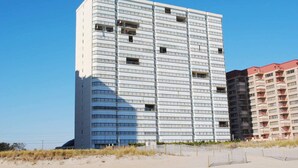 Een meerlaags hotel met een modern architectonisch ontwerp, met balkons en een gelijkmatige gevel.