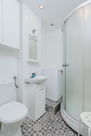A bathroom with a toilet, sink, and shower.
