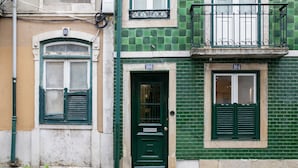 A building with a green door labeled "104" and a window with shutters. - Bairro Alto Design by Homing (Lisbon)