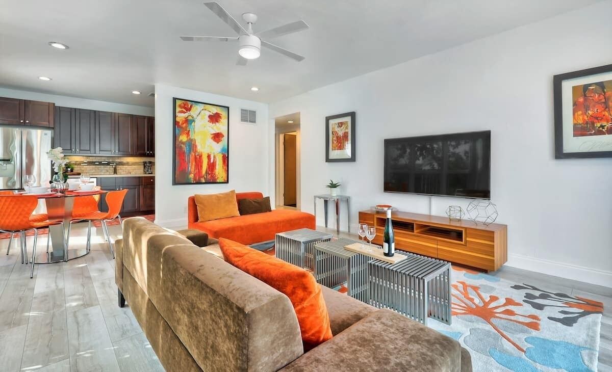 A modern living room with a sofa, coffee table, and artwork on the walls.