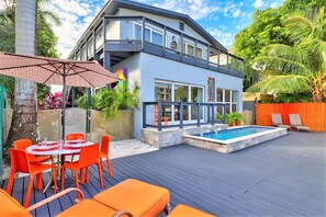 A modern two-story house with a swimming pool, outdoor seating, and tropical plants. - Orange Dream on the Water (Fort Lauderdale)