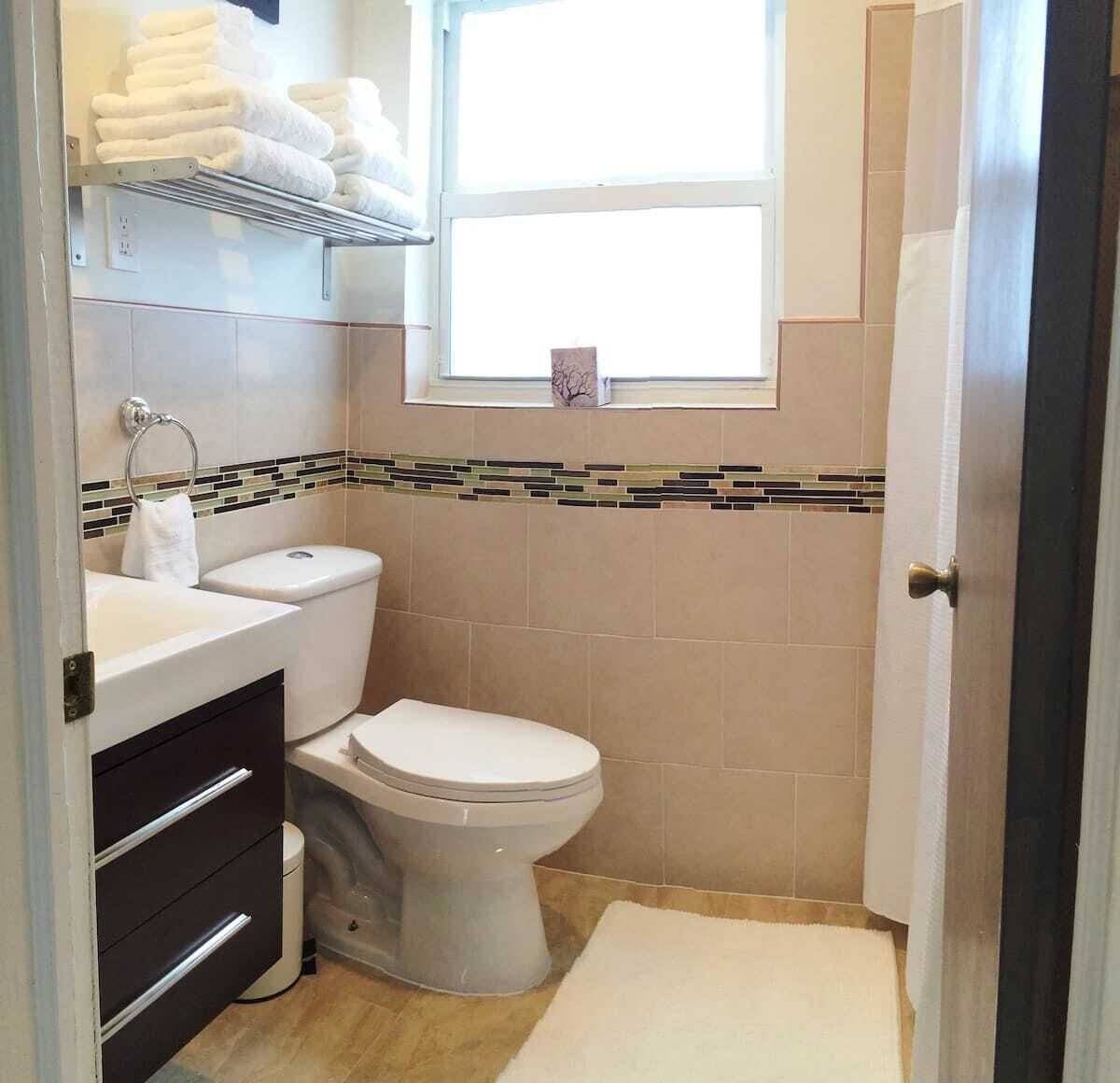 A small bathroom with a toilet, sink, and a towel rack.