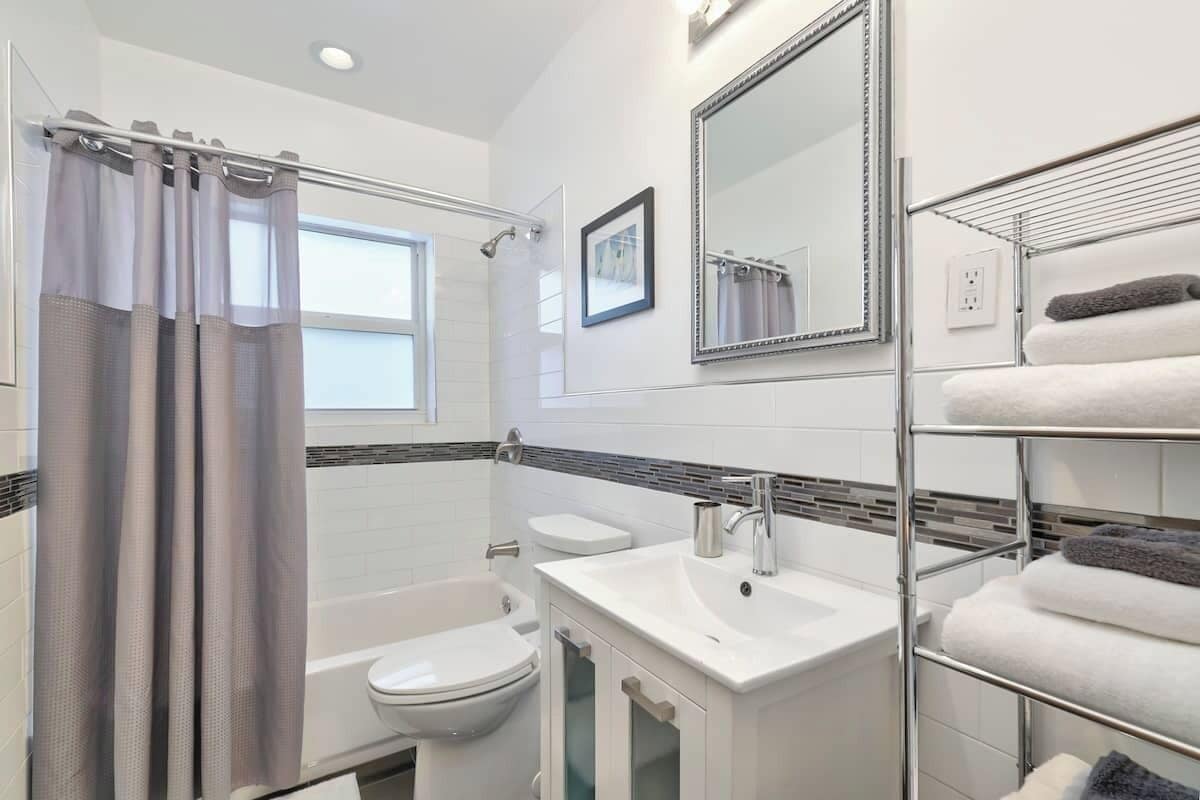 Une salle de bain moderne équipée d’une douche, de toilettes, d’un lavabo et d’un porte-serviettes.