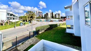 A modern urban street with a pedestrian crossing, greenery, and multi-story buildings. - Vilamoura SEA Village 2 by Homing (Loulé)