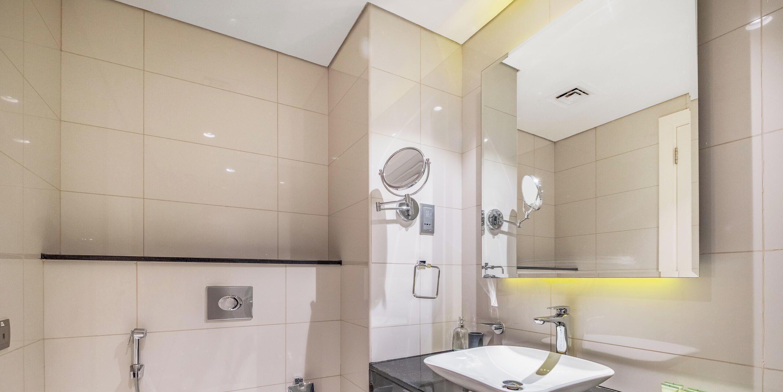 A modern bathroom with a toilet, shower, and sink.