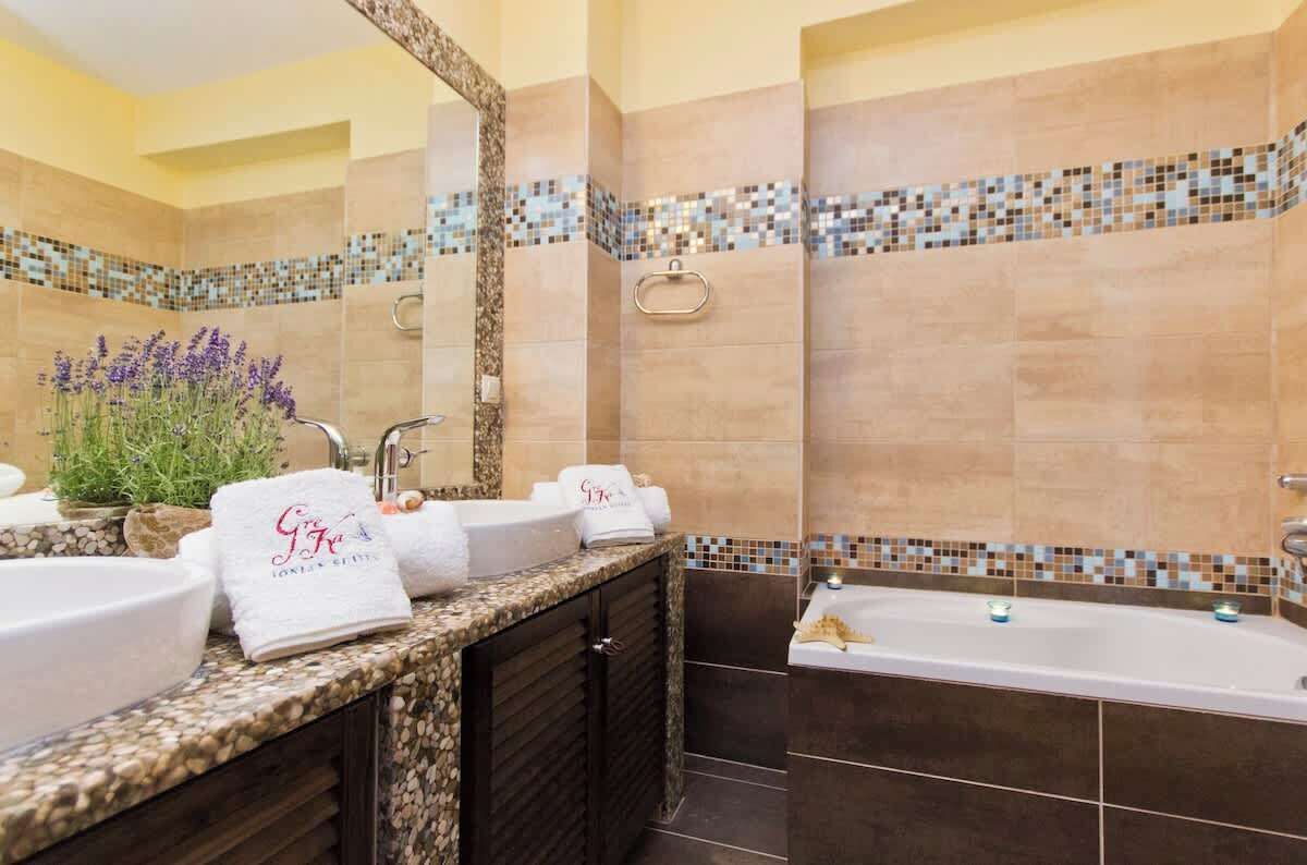 A bathroom with two sinks, a bathtub, and a mirror.