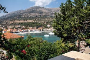 A coastal town with buildings, a marina, and a mountain in the background.