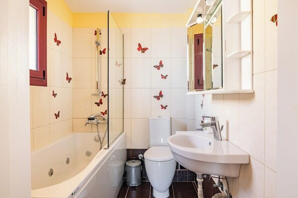 A bathroom with a bathtub, toilet, and sink.