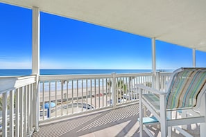 Un balcon avec vue sur la plage et l’océan.