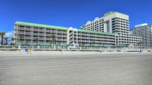 Un hotel grande con varios pisos, balcones y techo verde.