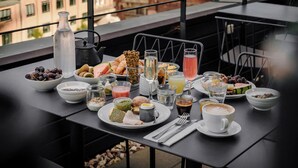 Una mesa de comedor con alimentos para el desayuno y vistas a edificios históricos.