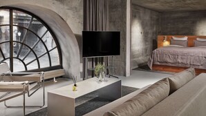 Un dormitorio moderno con un ventanal grande, un televisor de pantalla plana, una cama y un diseño minimalista.