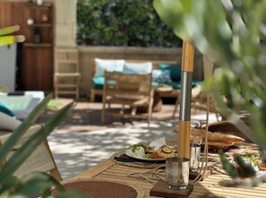 An outdoor dining area with a table set for two, featuring a meal, drinks, and a candle. - Villa Lepois & Spa 5 ***** (Nancy)