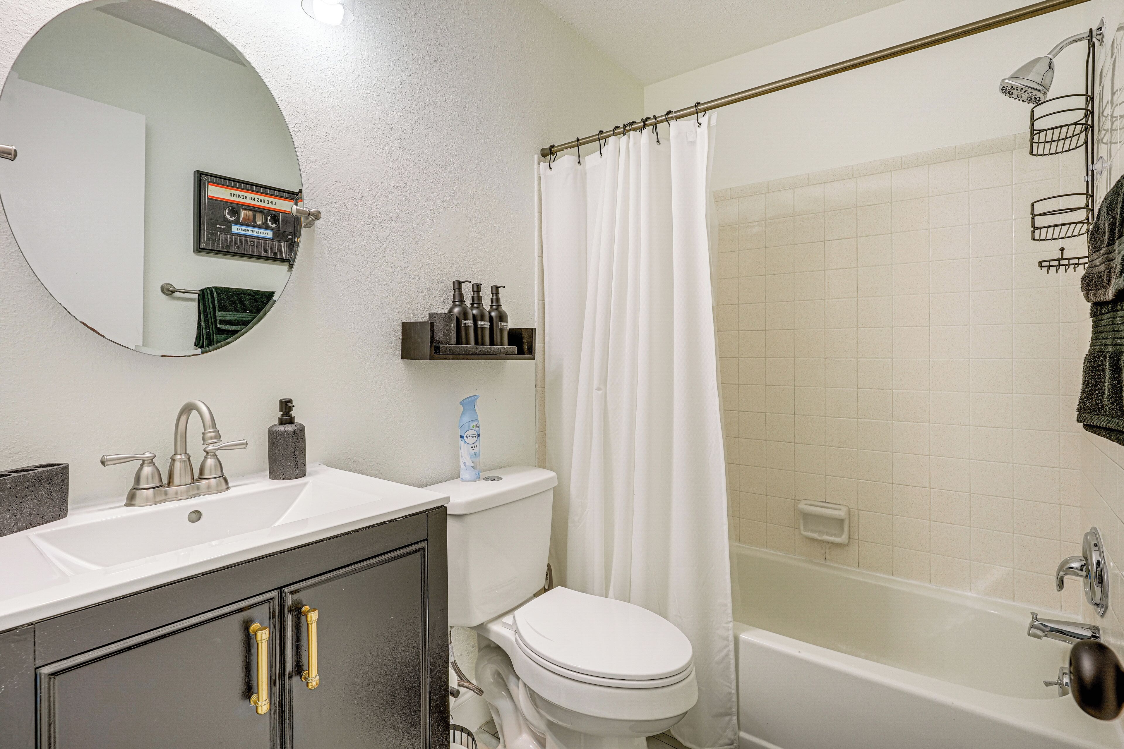 A bathroom with a white sink, a toilet, a bathtub, and a shower curtain.