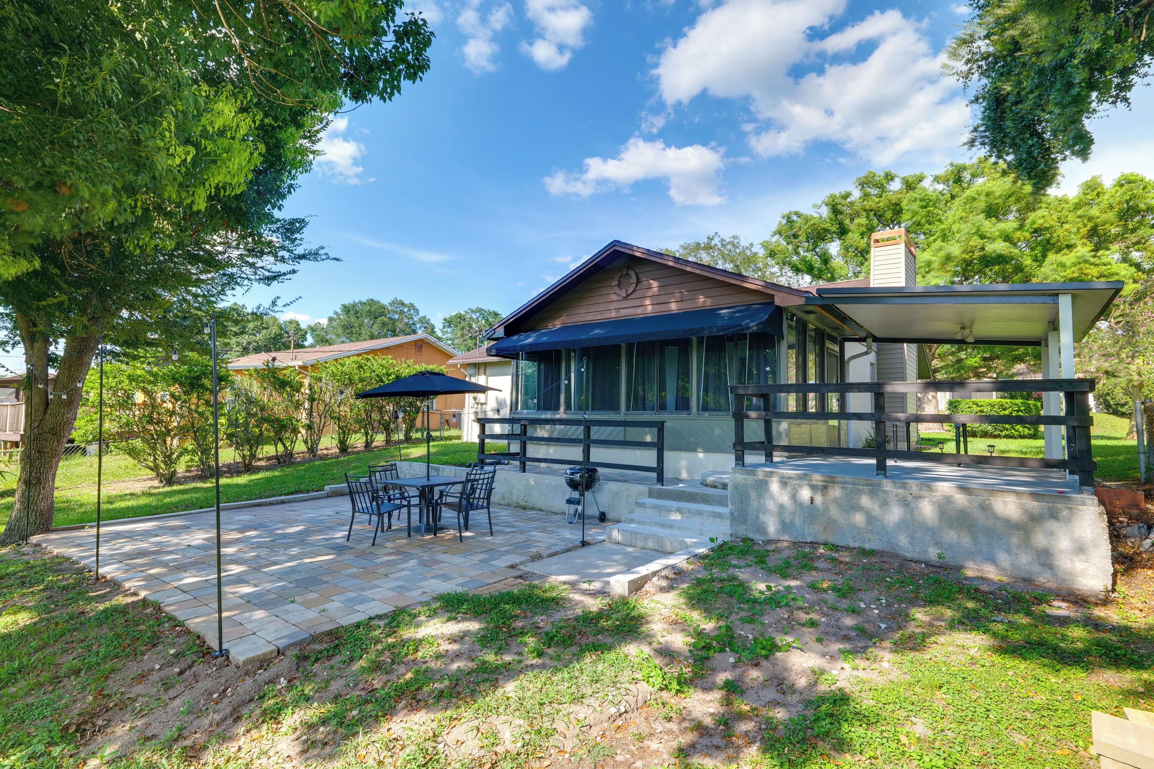 Una casa moderna amb un patio, mobiliari exterior i una zona coberta.