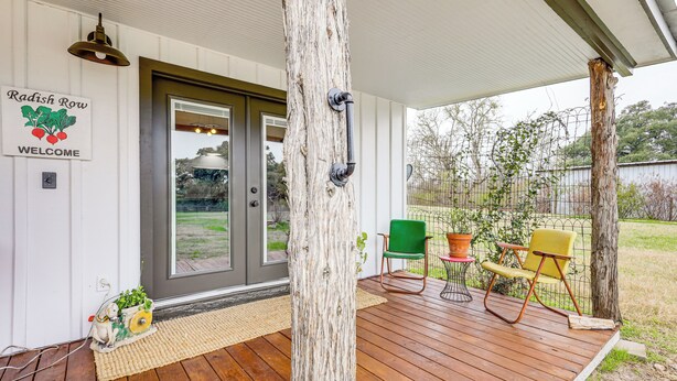 A wooden deck with a welcome sign, a door, and outdoor furniture. - Large Yard + Pond: Fayetteville Rural Retreat (Fayetteville)