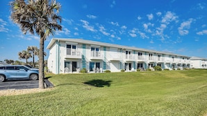 A row of motel buildings with balconies, a parking area, and a well-maintained lawn. - Walk to Ocean: Family Retreat in Ormond Beach! (Ormond Beach)