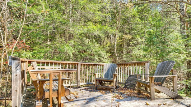 A wooden deck with Adirondack chairs and a table, surrounded by a forest. - Hike, Ski & Unwind: Cabin w/ Deck in Chester! (Chester)