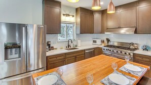 A modern kitchen with stainless steel appliances, wooden cabinets, and pendant lighting. - Game Room & Deck: Pet-friendly Lake Arrowhead Home (Lake Arrowhead)