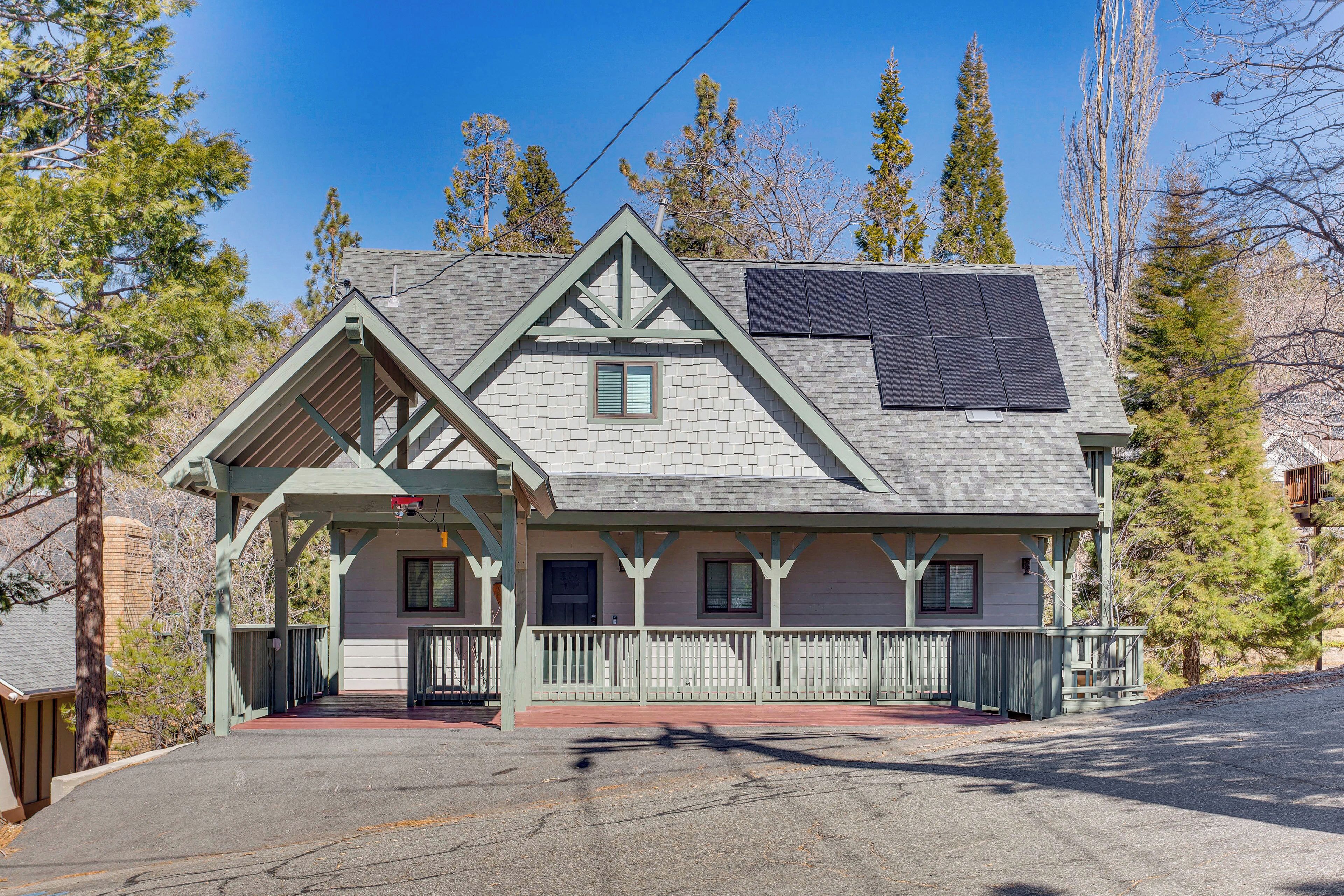 A two-story building with a gabled roof, solar panels, and a covered porch.