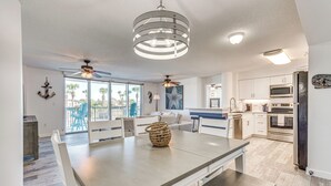 A modern kitchen with white cabinets, stainless steel appliances, and a large island with seating. - Waterfront Fort Walton Beach Condo: Pool Access! (Fort Walton Beach)
