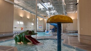 An indoor swimming pool with a large frog sculpture and a water slide. - Rockies Hideaway - Pool, Waterslide & Hot Tub (Canmore)