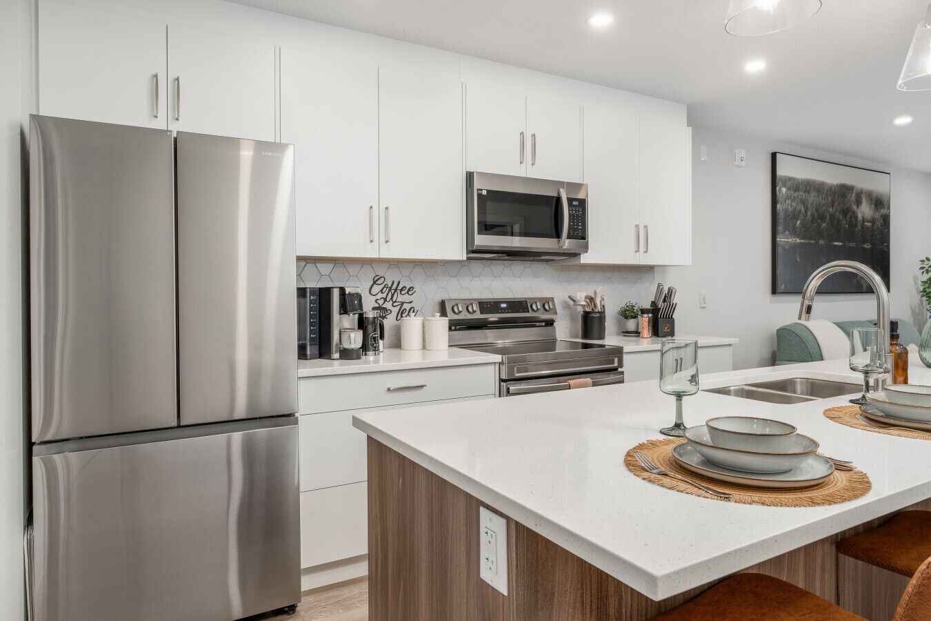 A modern kitchen with stainless steel appliances, a central island, and a microwave above the oven.