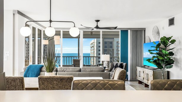Un salon moderne avec un balcon, de grandes fenêtres et un téléviseur.