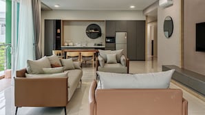 A modern living room with a ceiling fan, a dining area, and a kitchen in the background. - Mountain & Lake Views' Suite Cycas (Ipoh)